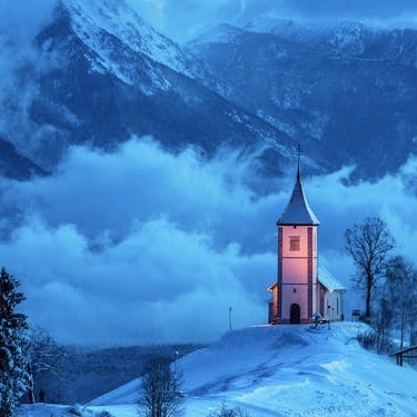 A tiny church in a huge, snow-covered valley